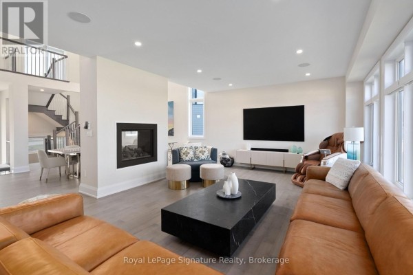 Bright living room with a sectional sofa, large windows, and a black marble coffee table. - 110 Cattail Crescent, Blue Mountains
