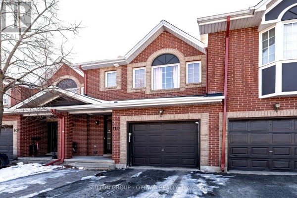 Brick townhouse exterior with attached garage and arched window - 110 Chartley Private Ottawa