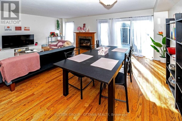 Living room with fireplace, dining table, and hardwood floors - 110 Chartley Private Ottawa
