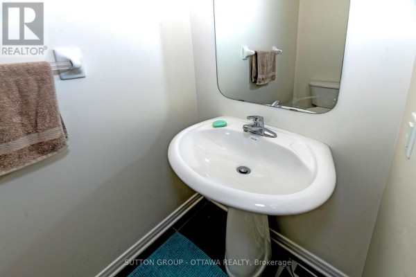Pedestal sink bathroom with mirror, toilet reflection, and towel rack - 110 Chartley Private Ottawa
