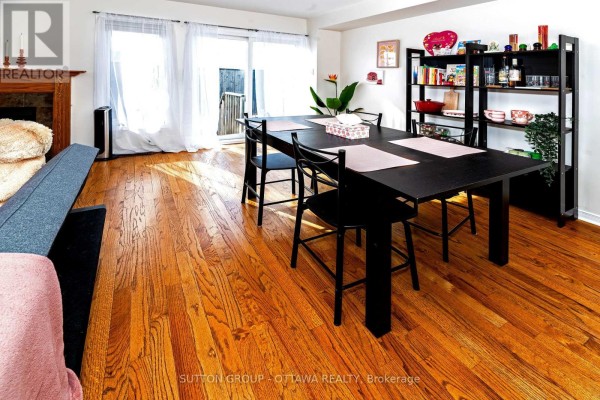 Dining area with black table, chairs, fireplace, and hardwood floors - 110 Chartley Private Ottawa