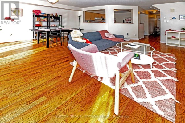 Living and dining area with hardwood floors, sofa, armchairs, and pass-through windows - 110 Chartley Private Ottawa