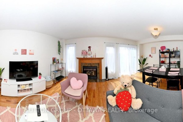 Living room with fireplace, hardwood floors, dining area, and kitchen view - 110 Chartley Private Ottawa