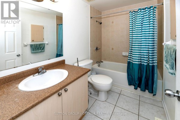 Bathroom with vanity, sink, toilet, tub, and striped shower curtain - 110 Chartley Private Ottawa