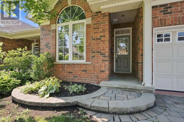 Close-up of townhouse entrance with arched window and landscaping. - 110 Heathercrest Private, Ottawa