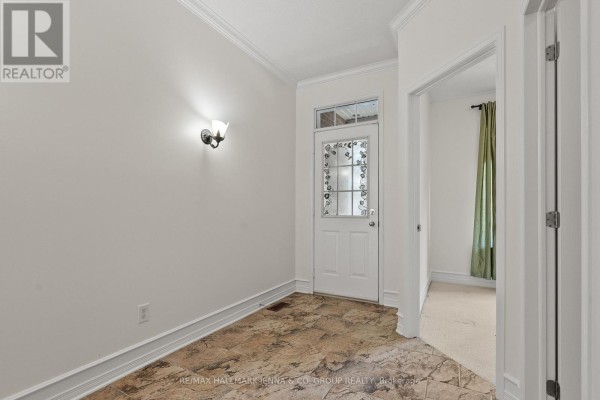 Interior view of entryway with tiled floor, white door and sconce. - 110 Heathercrest Private, Ottawa
