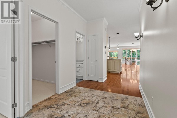 Hallway with hardwood floors, closet, bathroom, and open-concept living area. - 110 Heathercrest Private, Ottawa