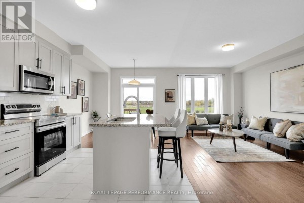 Modern kitchen with stainless steel appliances, granite island, and large windows - 110 Main Halyard Lane, Ottawa