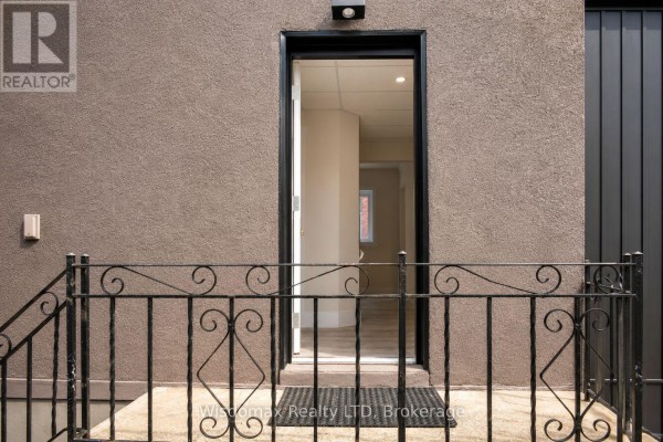 View of the front entrance with an open door revealing a hallway and interior rooms. - 110 Queen Street S, Thorold