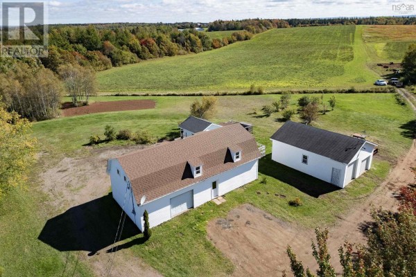 Aerial view of a white barn and detached garage on a grassy lot. - 1100 Highway 6, Warren