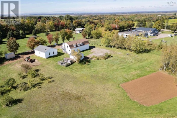 Aerial view of a rural property with multiple outbuildings and surrounding fields. - 1100 Highway 6, Warren