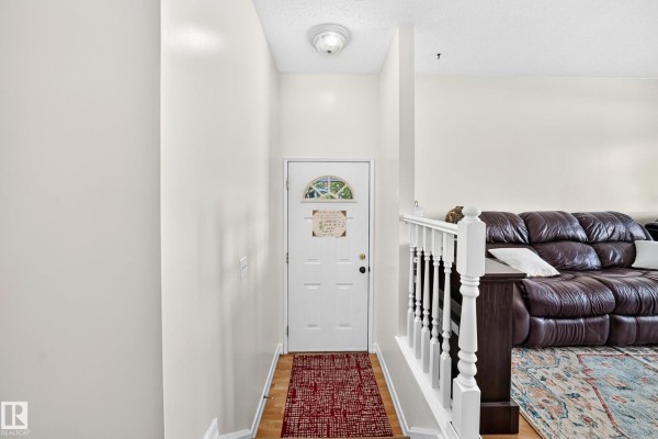 Front entryway with a white door, red rug, and light-colored walls. - 11007 173a Av Nw, Edmonton