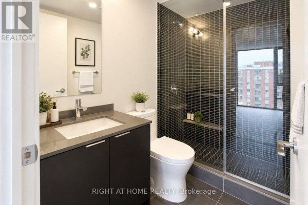 A second bathroom featuring a walk-in shower with black tile and a grey vanity with sink. - 1101 - 1 Jarvis Street, Hamilton