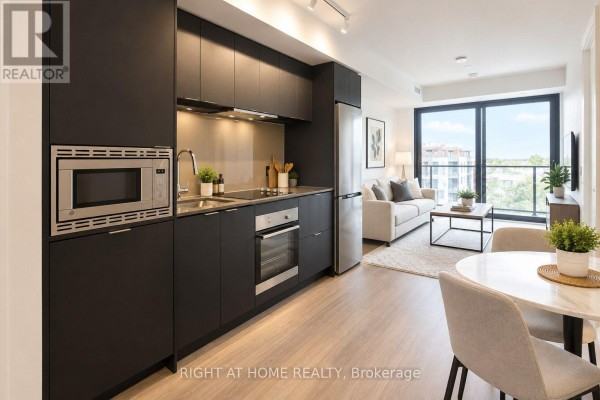 Open concept living space with a modern kitchen, dining area, and living room with large windows. - 1101 - 1 Jarvis Street, Hamilton
