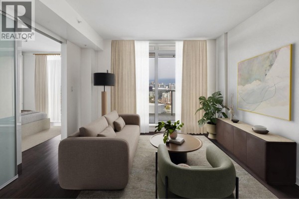 Living room with beige sofa, modern armchair, coffee table, and balcony view. - 1101 285 E 10th Avenue, Vancouver
