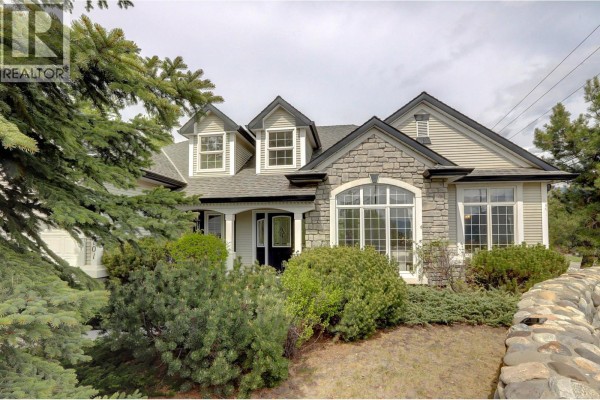 Close-up of the front porch with grey wooden walkway and landscaping. - 1101 Phoenix Drive, Vernon