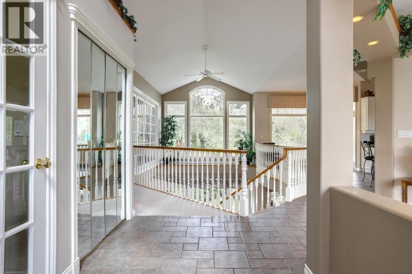 View of the garage door and entrance to the house, surrounded by trees. - 1101 Phoenix Drive, Vernon