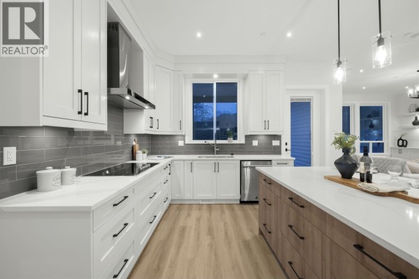 Rear exterior of a white house with large windows and a fenced backyard. - 11018 243b Street, Maple Ridge