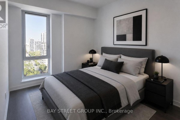 Bedroom with mirrored sliding closet doors and dark wood laminate flooring. - 1102 - 10 Oak Street, Toronto