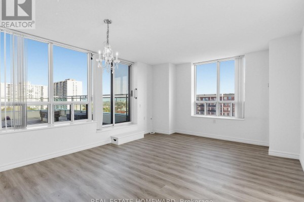 Open living area featuring a chandelier and access to balcony - 1102 - 2800 Warden Avenue, Toronto