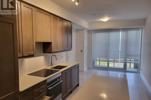 Hallway view of two grey apartment doors with ornate trim and a fire safety box. - 1102 - 30 Elm Drive W, Mississauga