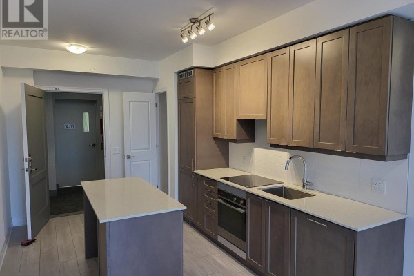 Kitchen interior with dark grey cabinets, countertop, and a large window with blinds. - 1102 - 30 Elm Drive W, Mississauga