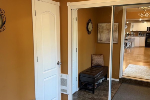Entranceway with tan walls, white doors, a bench with storage, and a mirrored closet. - 1102 Alfred Street, Cochin