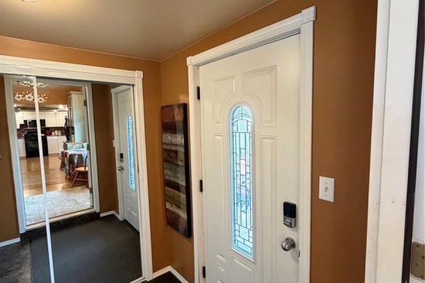 Front entryway with tan walls, white door with glass panels, and a dark grey mat. - 1102 Alfred Street, Cochin
