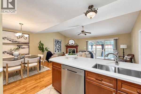 Kitchen island with stainless steel sink, overlooking the dining area and living room. - 11027 Leathorne, Windsor