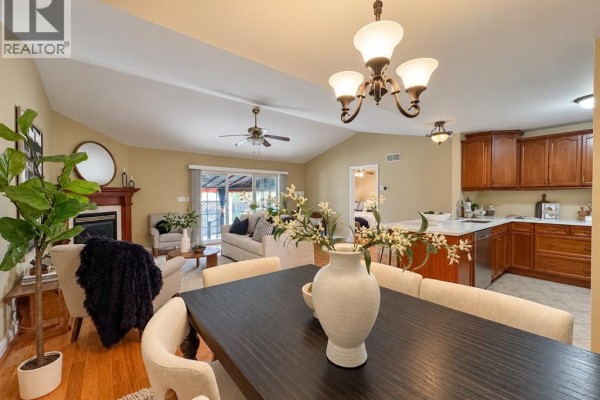 Open concept dining, living, and kitchen area with vaulted ceilings and fireplace. - 11027 Leathorne, Windsor
