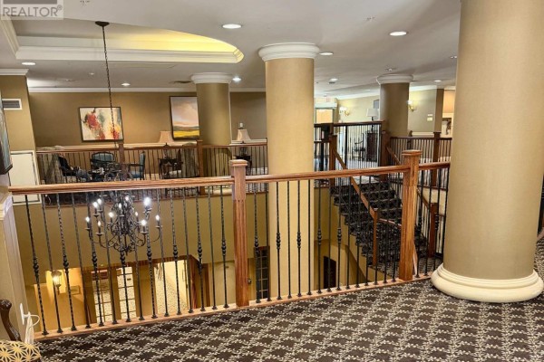 Interior view of the building lobby with carpeted floors and decorative chandelier. - 1103 - 350 Princess Royal Drive, Mississauga
