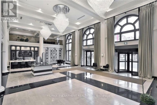 Spacious hotel-like lobby with marble floors, high ceilings, chandeliers, and seating areas. - 1105 - 112 King Street E, Hamilton