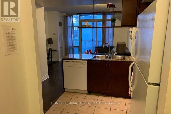 Kitchen with stainless steel appliances, granite countertops, and dark wood cabinets. - 1105 - 35 Mariner Terrace, Toronto