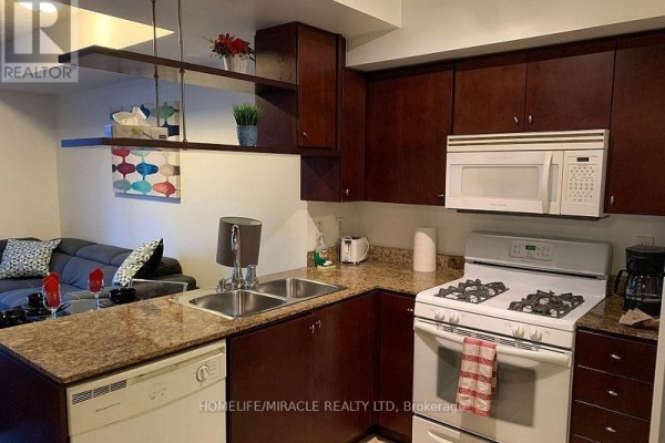 Kitchen counter with sink, gas stove, microwave, and espresso machine. - 1105 - 35 Mariner Terrace, Toronto
