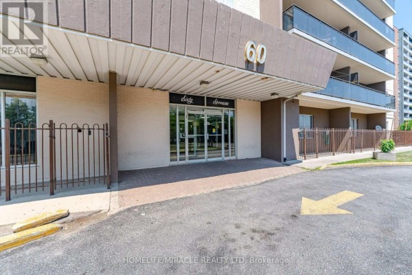Entrance to the apartment building at 60 Stevenson Road with glass doors and signage. - 1105 - 60 Stevenson Road, Toronto