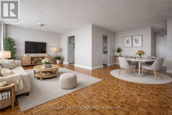 Living and dining area with parquet flooring, a sofa, coffee table, and dining set. - 1105 - 890 Jane Street, Toronto