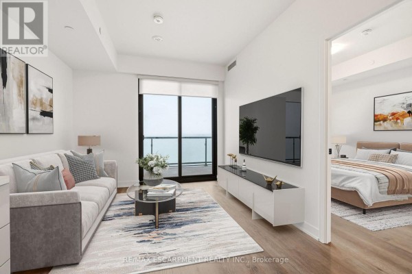 View of the kitchen and living space, showing stainless steel appliances and balcony access. - 1106 - 2075 Lakeshore Road, Burlington