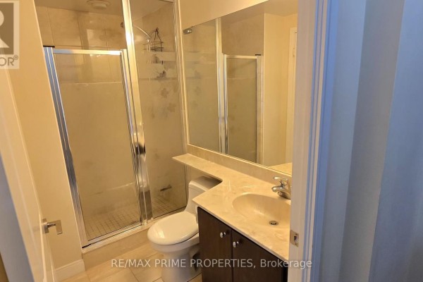 Compact bathroom with toilet, vanity, sink, and a glass-enclosed shower stall. - 1106 - 50 Absolute Avenue, Mississauga