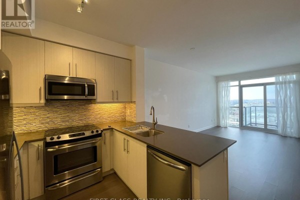 Open concept kitchen with stainless steel appliances, grey counters and backsplash, facing living area. - 1106 - 55 Oneida Crescent, Richmond Hill