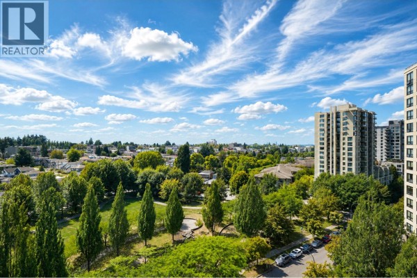 View of green trees and buildings from a high-rise apartment window. - 1106 5380 Oben Street, Vancouver