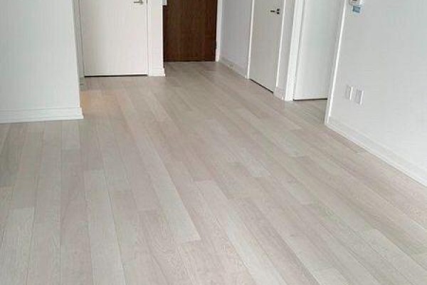 Hallway with light wood floors, white walls, and two closed doors. - 1107 - 115 Mcmahon Drive, Toronto