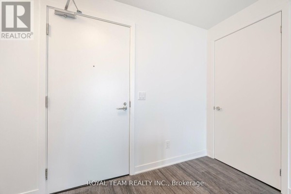 Interior hallway with white doors and grey wood-look flooring leading to different units. - 1107 - 185 Alberta Avenue, Toronto