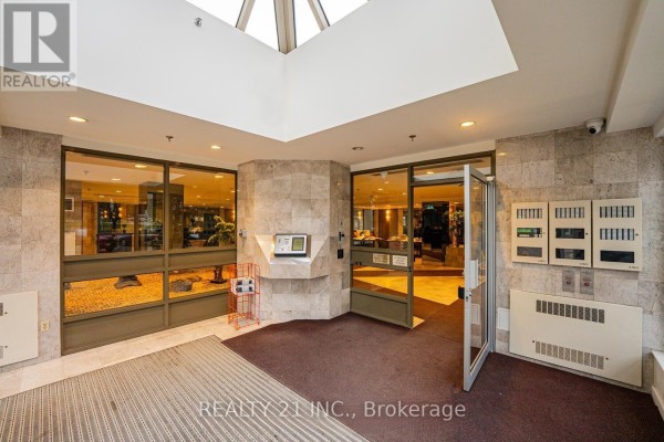 Building entrance with marble walls, glass doors, and a skylight above. - 1107 - 3233 Eglinton Avenue E, Toronto