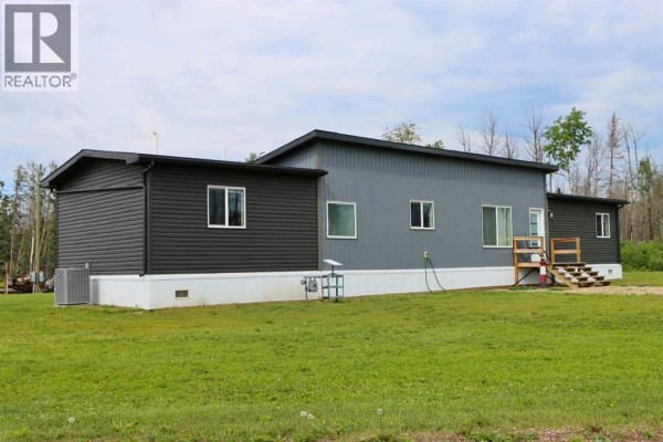 Rear exterior of the mobile home showing dark grey siding, white skirting, and a central grey section with windows. - 111, 71127 Range Road 234, Rural Greenview No  16, M D  Of