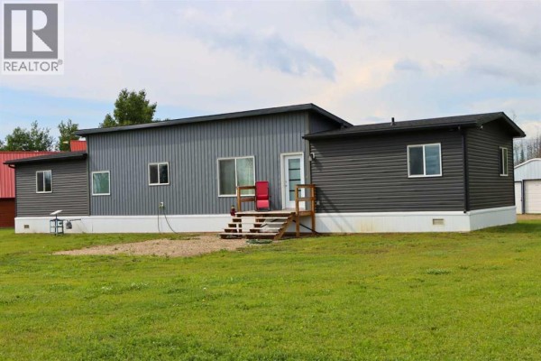 Side view of the mobile home with dark grey siding, white skirting, and an air conditioning unit on the left. - 111, 71127 Range Road 234, Rural Greenview No  16, M D  Of