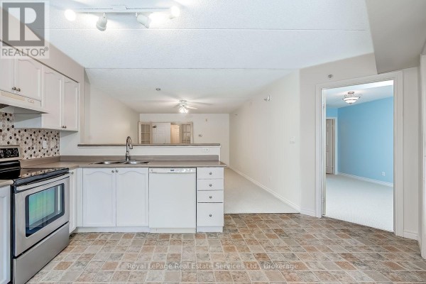 View from kitchen into living area and hallway. - 111 - 1460 Bishops Gate, Oakville