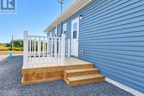 Close-up view of a white railing deck with wooden steps leading to a white door. - 111-113 Branch Hill Road, Winterland