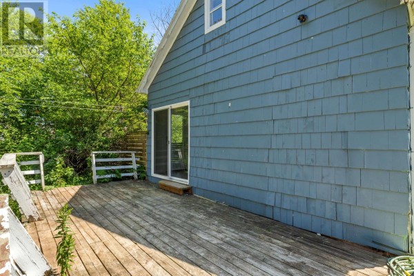 Wooden deck attached to the side of the blue house with a sliding glass door. - 111 Beach Grove, Charlottetown