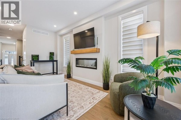 Bright bedroom with a king-sized bed, teal accent blanket, and an ensuite bathroom visible through the doorway. - 111 Catherine Street, New Hamburg