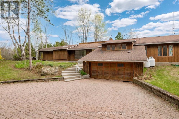 Close-up of the garage door and paved driveway in front of the brown house. - 111 Elmgrove Road, Drummond/north Elmsley